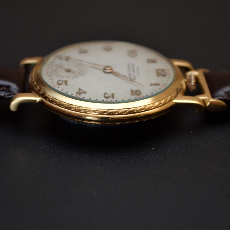 Rolex 1920s trench watch side profile, guilloche bezel detail and fluted crown, gold-plated case on leather strap