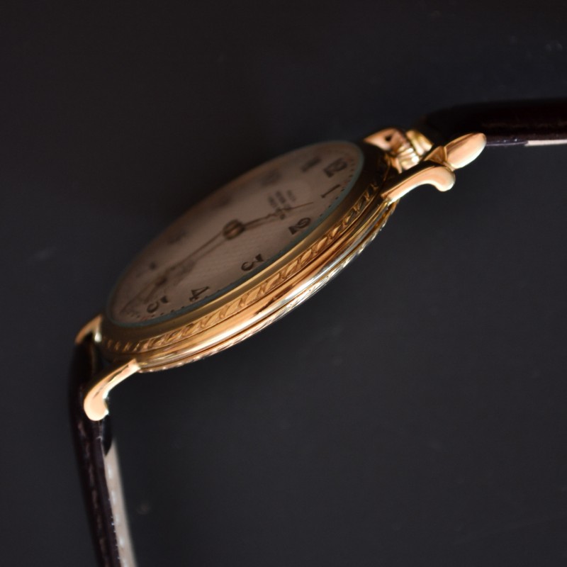 Rolex 1920s trench watch side profile, showing case thickness, fluted crown, and engraved guilloche bezel decoration