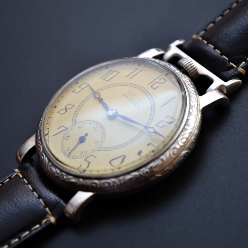 Rolex Unicorn 45mm art deco watch, angled front view showing ivory dial, engraved guilloche bezel and wire lugs with leather strap, circa 1930s