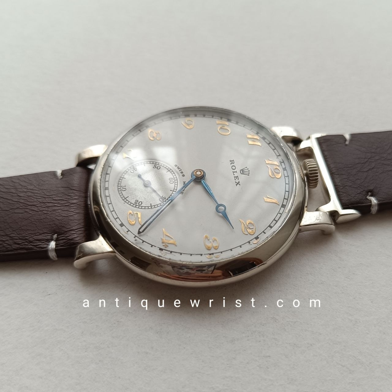Detailed front shot of a vintage Rolex field watch – beige dial with rose-gilt indices, heat-blued hands, and a 41.5mm crystal in excellent condition.