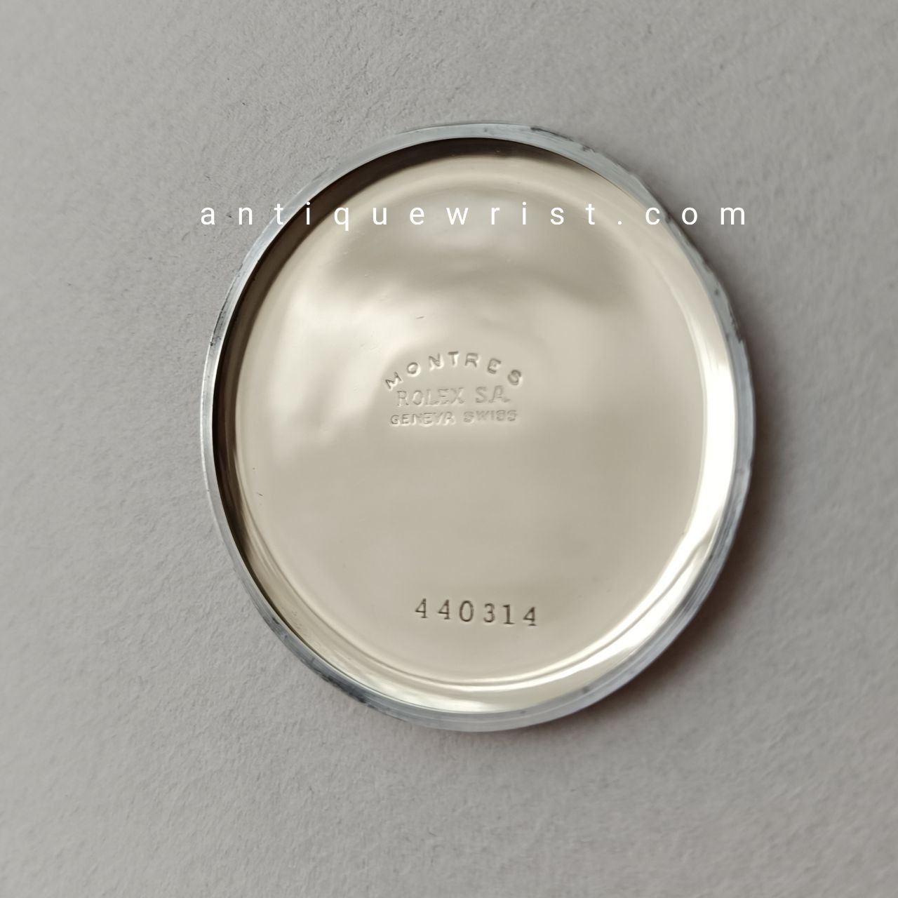 Open caseback revealing the mechanical hand-winding movement inside the military-style Rolex, with visible jewelled bearings, gears, and the balance wheel assembly.