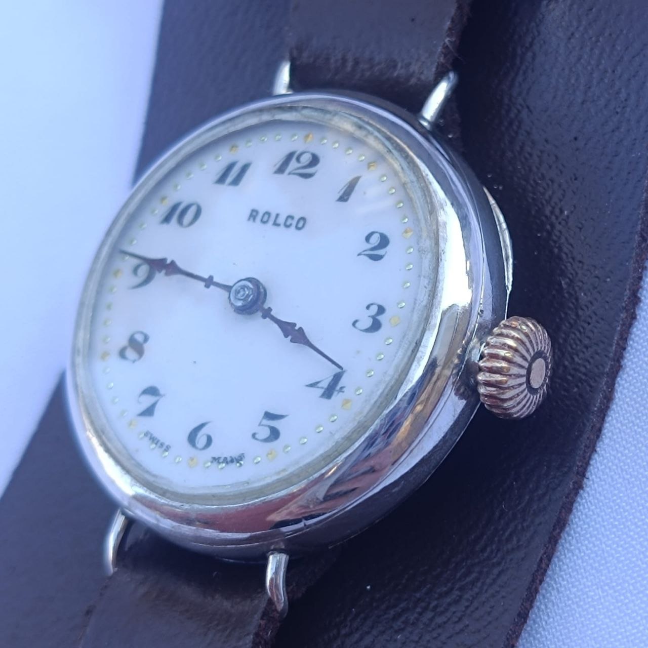 Vintage Rolex Rolco wristwatch angled view showing original SWISS MADE dial, gold minute markers, and solid sterling silver case.