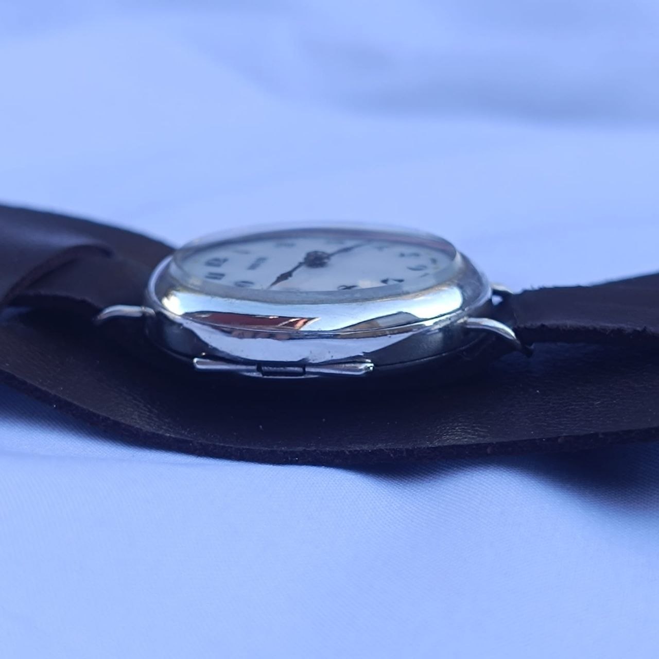 Right-side view of the solid 925 sterling silver case showing honest wear and vintage trench-style strap attachment.