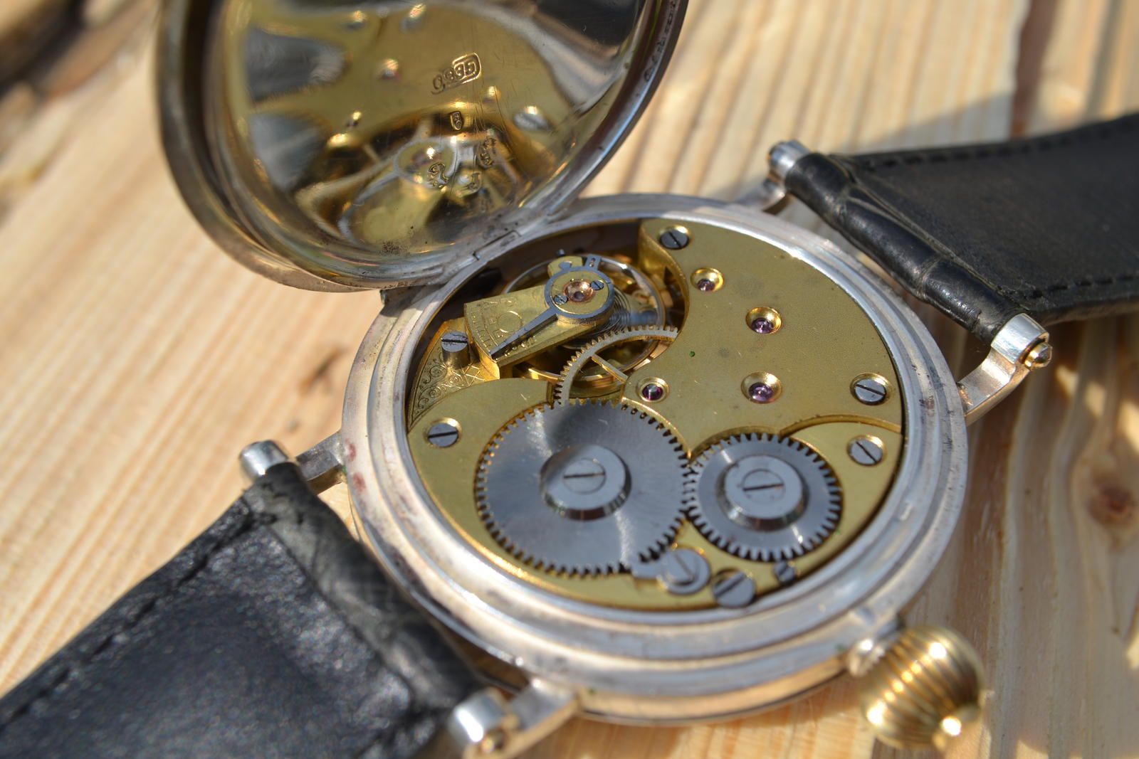Original Omega pocket watch movement visible through open case back after wristwatch conversion